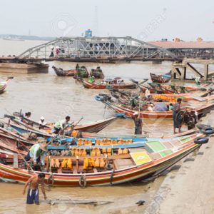 Yangon, Myanmar - April 6, 2014: A man navigates his boat full of passengers out of the busy Yangon port, Yangon is the largest city of Myanmar and the Port of Yangon is the country's most import port